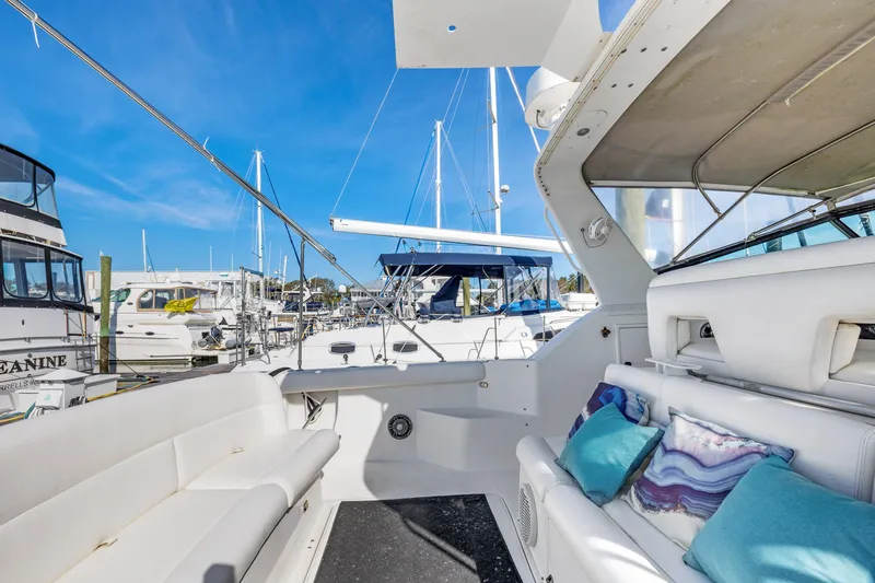 Slide: The Image of 1999 Tiara Yachts 4000 Express at marina, featuring spacious seating and modern design. - 3