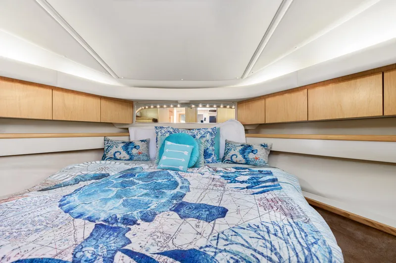 Slide: The Image of 1999 Tiara Yachts 4000 Express cabin with turtle-themed bedding and wooden storage cabinets. - 6