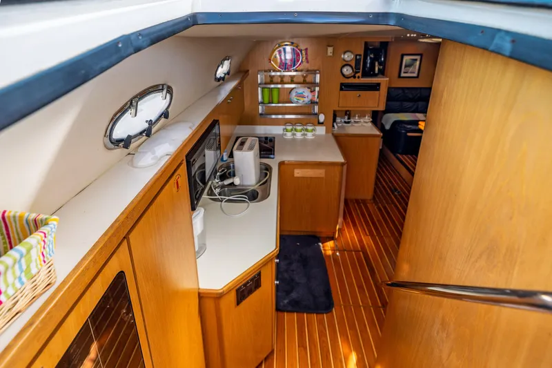 Slide: The Image of Interior of 1999 Tiara Yachts 4000 Express with wooden cabinetry and modern appliances. - 9