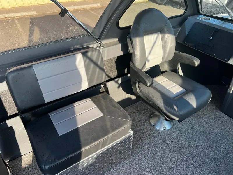 Slide: The Image of 2024 Fish Rite 180 Sportsman boat interior with black and gray seating. - 13