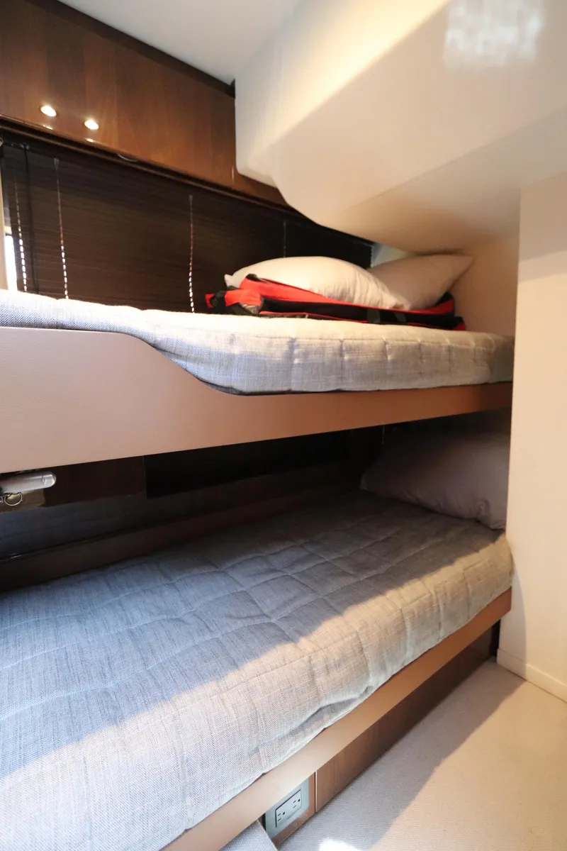 Slide: The Image of Bunk beds in 2018 Princess V58 yacht cabin, featuring cozy bedding and modern design. - 13