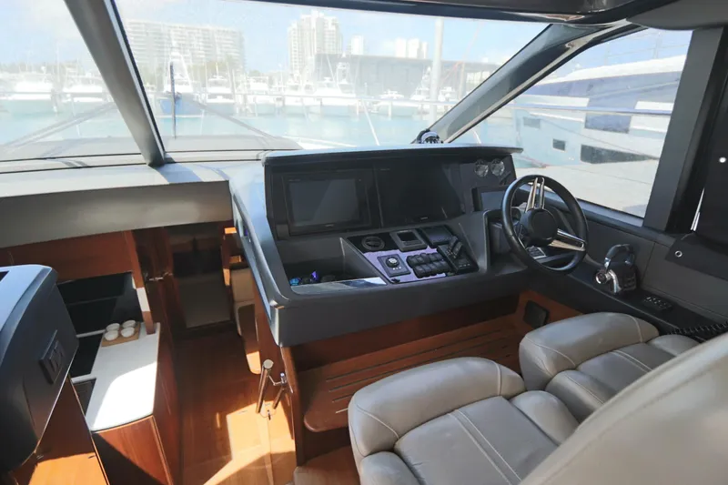 Slide: The Image of Interior of 2018 Princess V58 yacht cockpit with modern controls and leather seating. - 2
