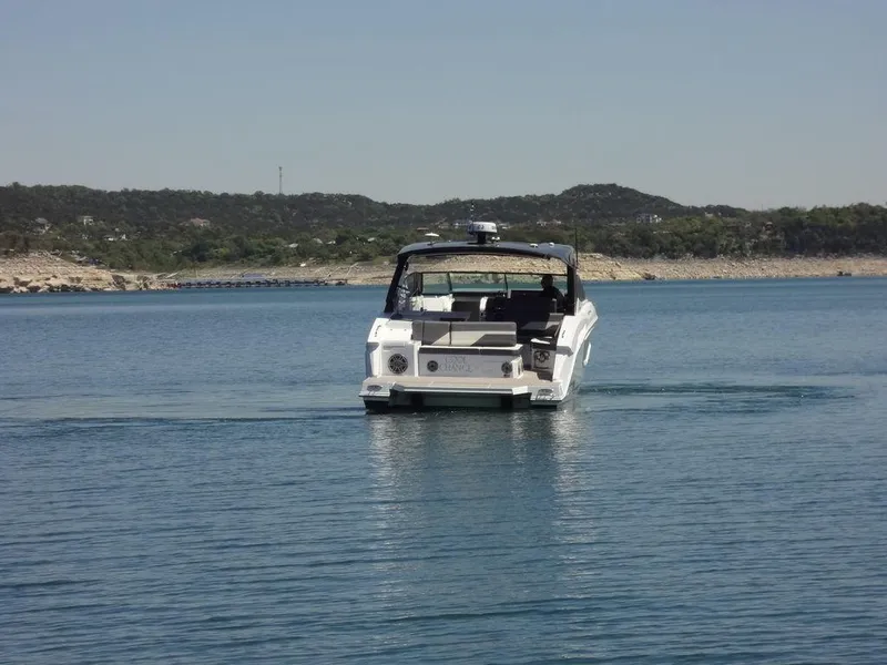 Slide: The Image of 2021 Cruisers Yachts 38 GLS I/O on a serene lake with distant hills. - 10