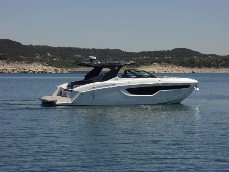Slide: The Image of 2021 Cruisers Yachts 38 GLS I/O on a calm lake with scenic background. - 11