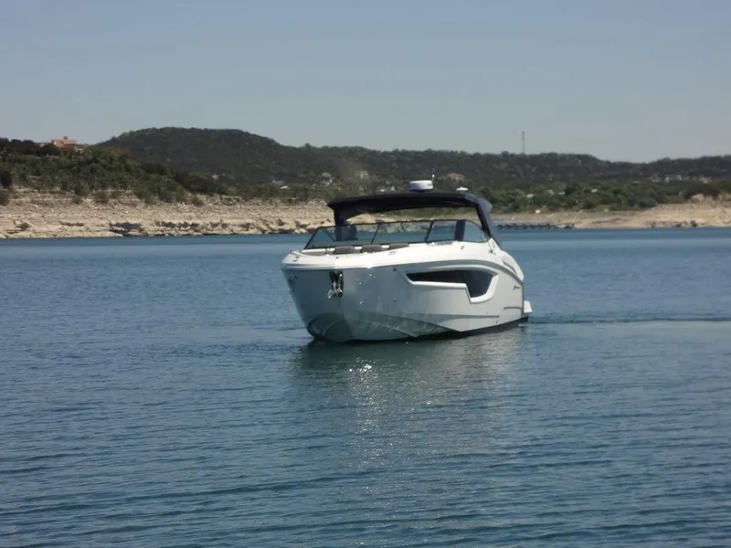 Slide: The Image of 2021 Cruisers Yachts 38 GLS I/O on a serene lake with hills in the background. - 15