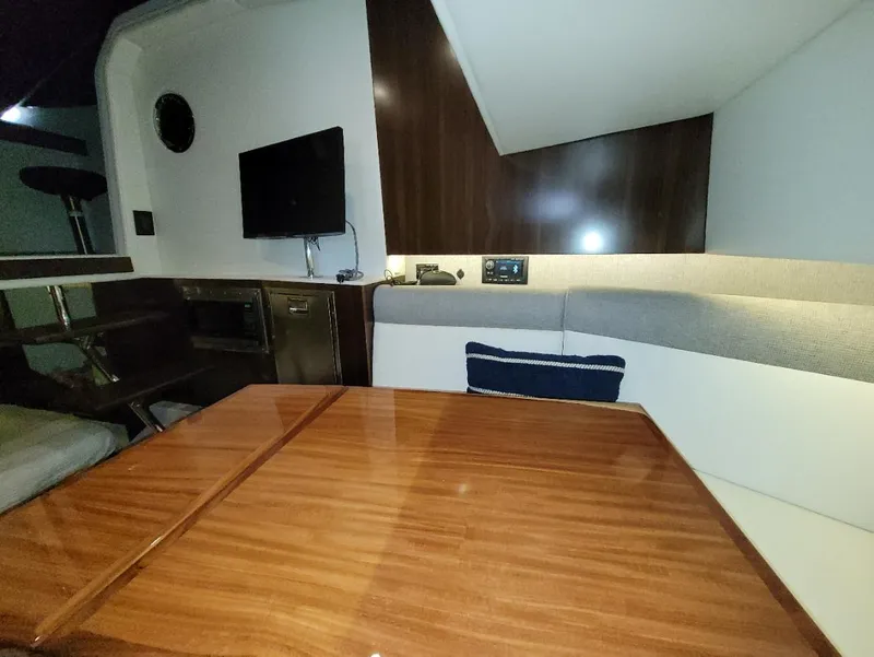 Slide: The Image of Interior of 2021 Cruisers Yachts 38 GLS I/O with wood table and seating area. - 22