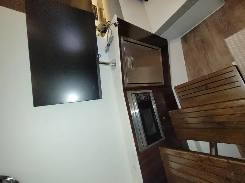 Slide: The Image of Interior of 2021 Cruisers Yachts 38 GLS I/O with TV, microwave, and wooden seating. - 34