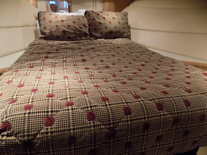 Slide: The Image of 1997 Hatteras 50 Convertible cabin with patterned bedspread and pillows. - 36