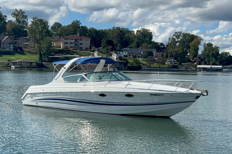 Slide: The Image of 2004 Formula 330 Sun Sport boat on a serene lake with scenic background. - 103