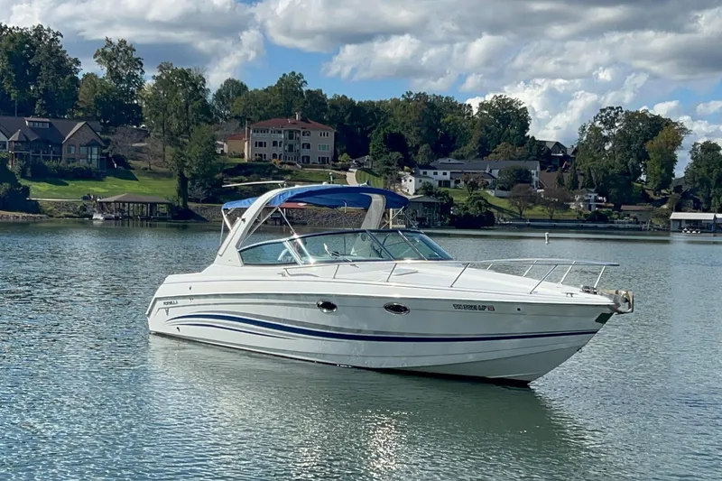 Slide: The Image of 2004 Formula 330 Sun Sport boat on a serene lake with houses in the background. - 105
