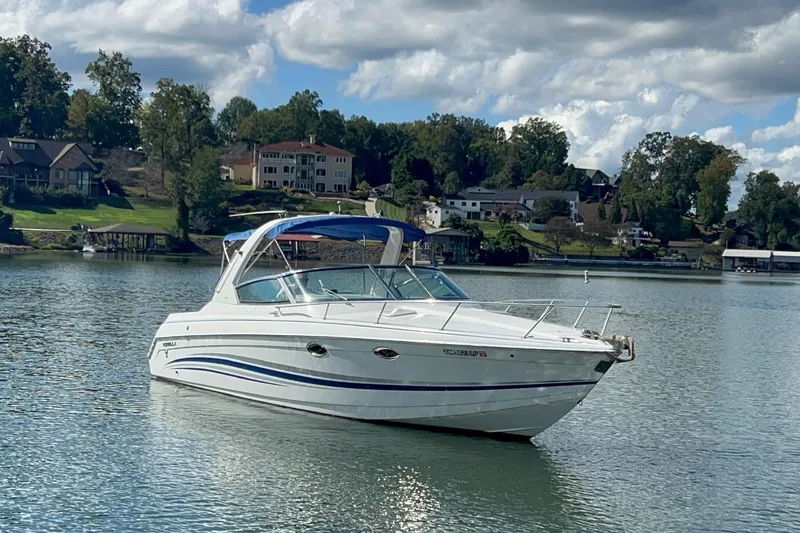 Slide: The Image of 2004 Formula 330 Sun Sport boat on a serene lake with houses in the background. - 106