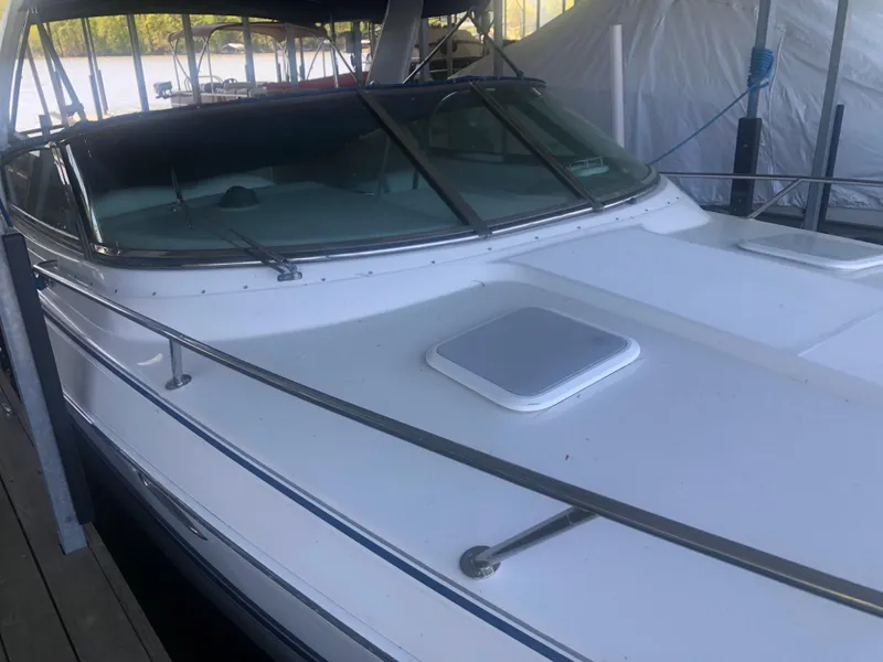 Slide: The Image of 2004 Formula 330 Sun Sport boat docked, showcasing sleek deck design and railing. - 13