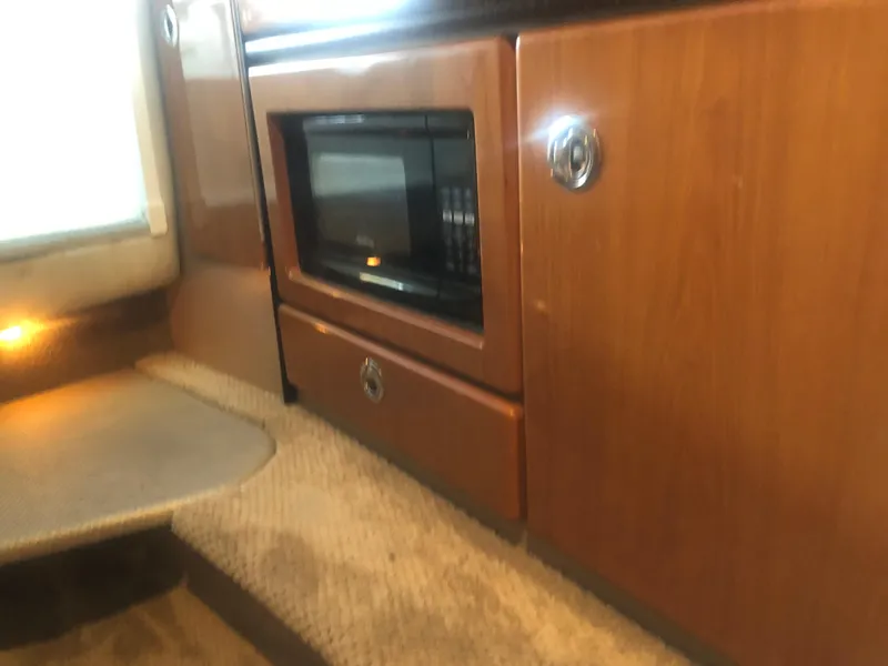 Slide: The Image of Interior cabin of a 2004 Formula 330 Sun Sport boat, featuring carpeted flooring and seating. - 32