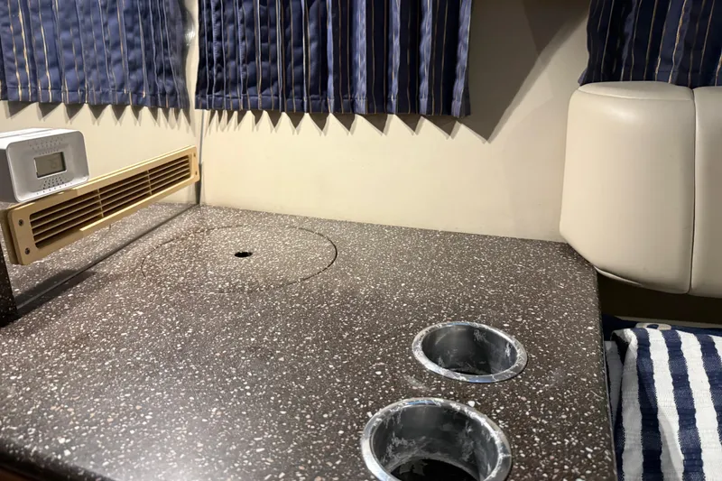 Slide: The Image of 2004 Formula 330 Sun Sport interior with countertop, cup holders, and striped curtains. - 48