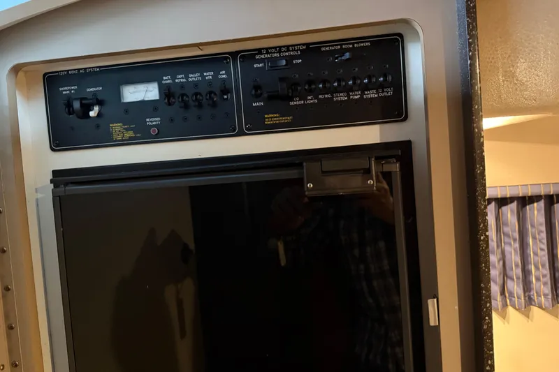 Slide: The Image of Control panel and refrigerator inside a 2004 Formula 330 Sun Sport boat cabin. - 49