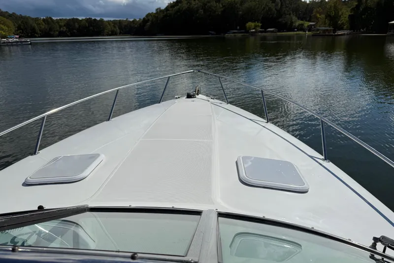 Slide: The Image of 2004 Formula 330 Sun Sport boat on a serene lake with lush greenery. - 56