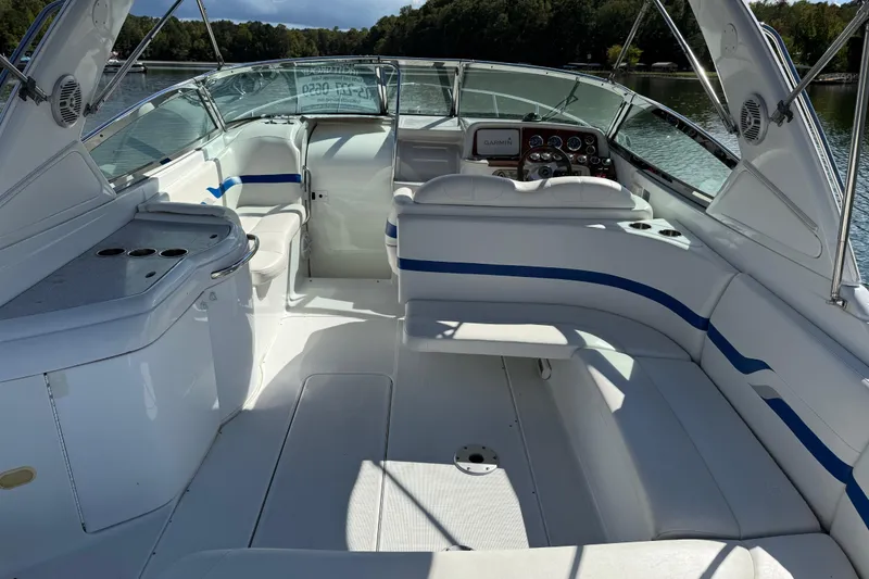 Slide: The Image of 2004 Formula 330 Sun Sport boat interior with white seating and blue accents on a lake. - 66