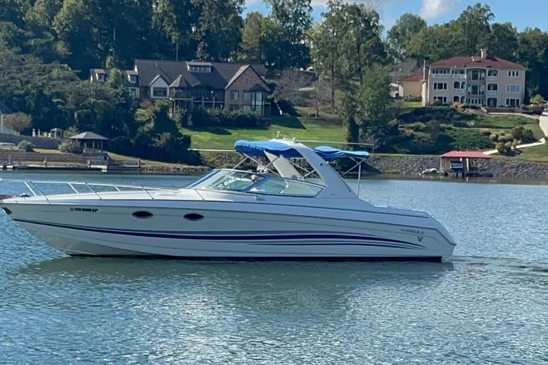 Slide: The Image of 2004 Formula 330 Sun Sport boat on a serene lake with luxury homes in the background. - 81