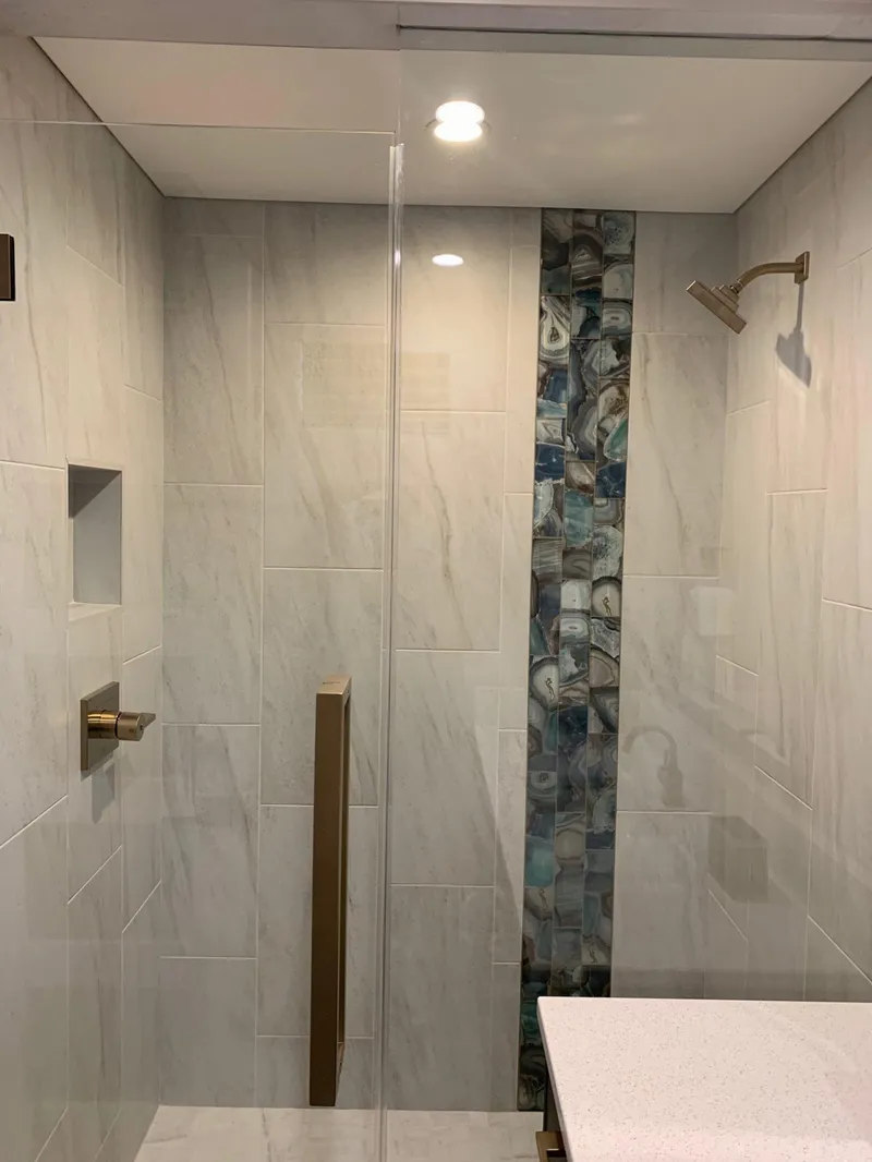 Slide: The Image of Modern shower with marble tiles, mosaic accent, and brass fixtures, Adonia Athena model 2019. - 10