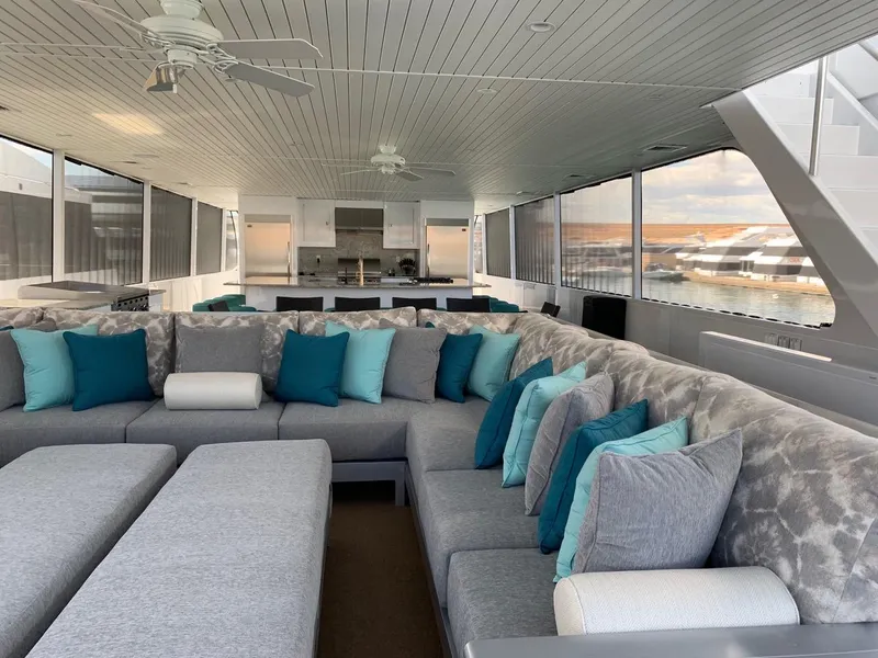 Slide: The Image of Luxurious yacht interior with spacious seating, modern design, and vibrant teal accents. - 12