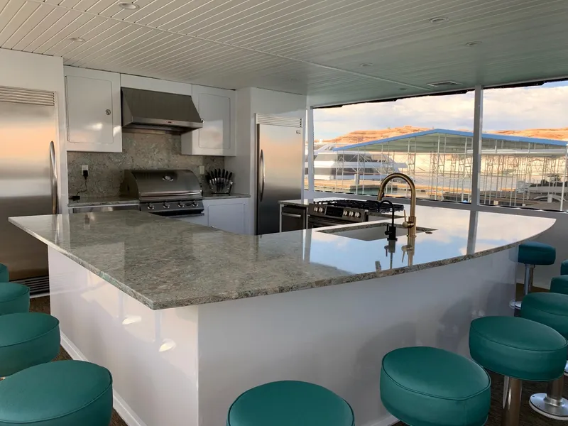 Slide: The Image of Modern kitchen on Adonia Athena share #2 houseboat, featuring granite countertops and teal stools, 2019 model. - 13