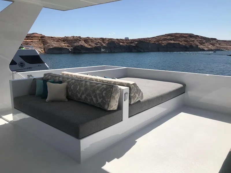 Slide: The Image of Luxurious Adonia Athena yacht deck with cushions, overlooking serene waters and rocky landscape, 2019 model. - 20