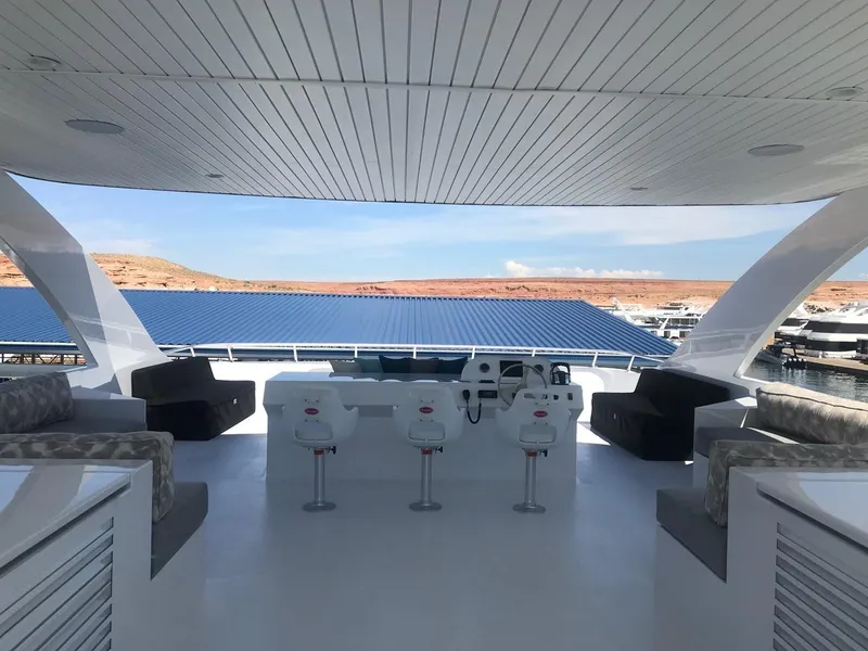 Slide: The Image of Luxurious 2019 Adonia Athena yacht deck with seating and helm, overlooking serene waters. - 21