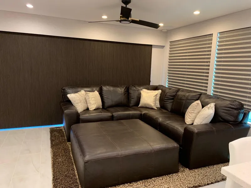 Slide: The Image of Modern living room with dark leather sectional sofa, large ottoman, and striped blinds, 2019 Adonia Athena. - 4