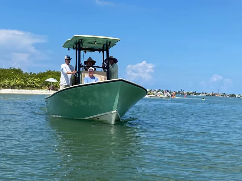 Slide: The Image of 2024 Exuma 22 EXTRA LITE boat cruising near a beach with people onboard. - 7