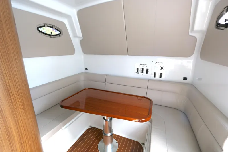 Slide: The Image of 2021 Yellowfin 54 Offshore cabin with elegant seating and wooden table. - 19