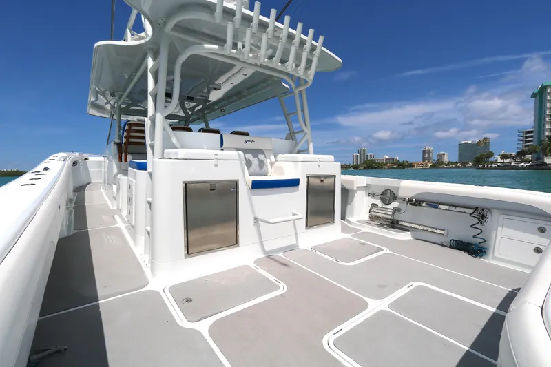 Slide: The Image of 2021 Yellowfin 54 Offshore boat deck with seating and storage, under clear blue sky. - 2