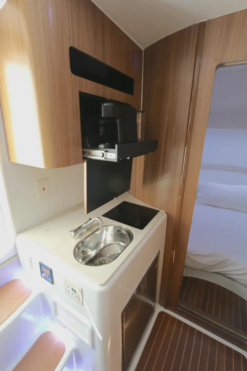 Slide: The Image of 2021 Yellowfin 54 Offshore interior with compact kitchenette and modern wood finish. - 20