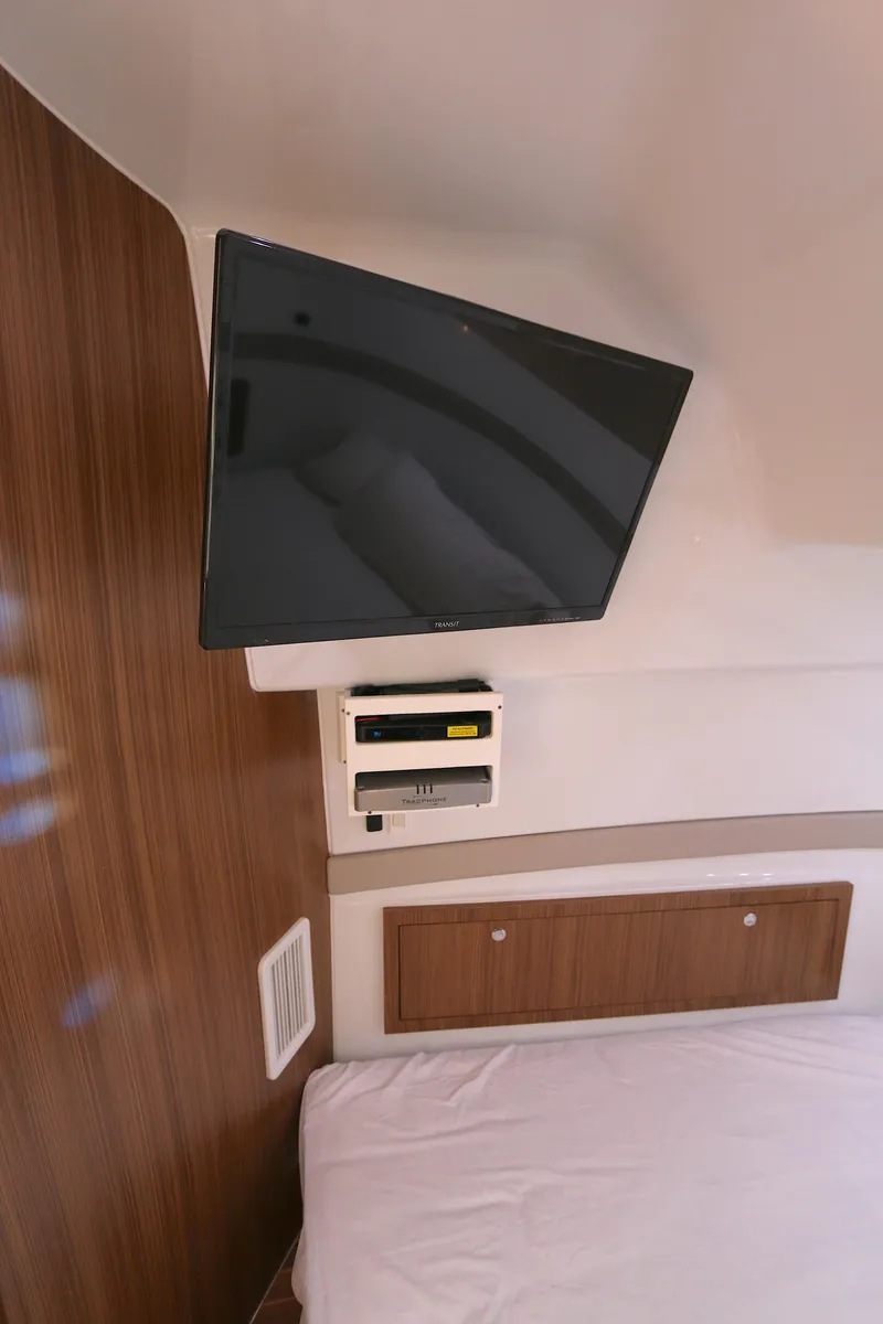 Slide: The Image of 2021 Yellowfin 54 Offshore cabin with mounted TV and wooden paneling. - 22