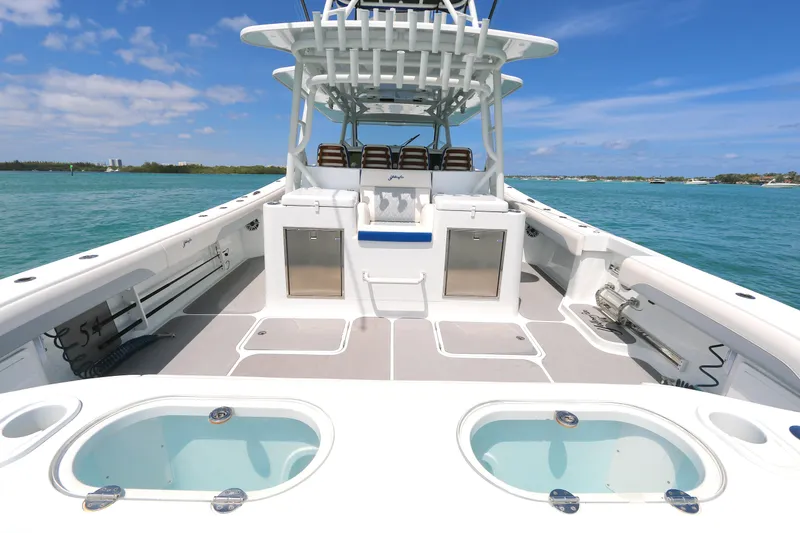 Slide: The Image of 2021 Yellowfin 54 Offshore boat on clear blue water, showcasing spacious deck and seating. - 3