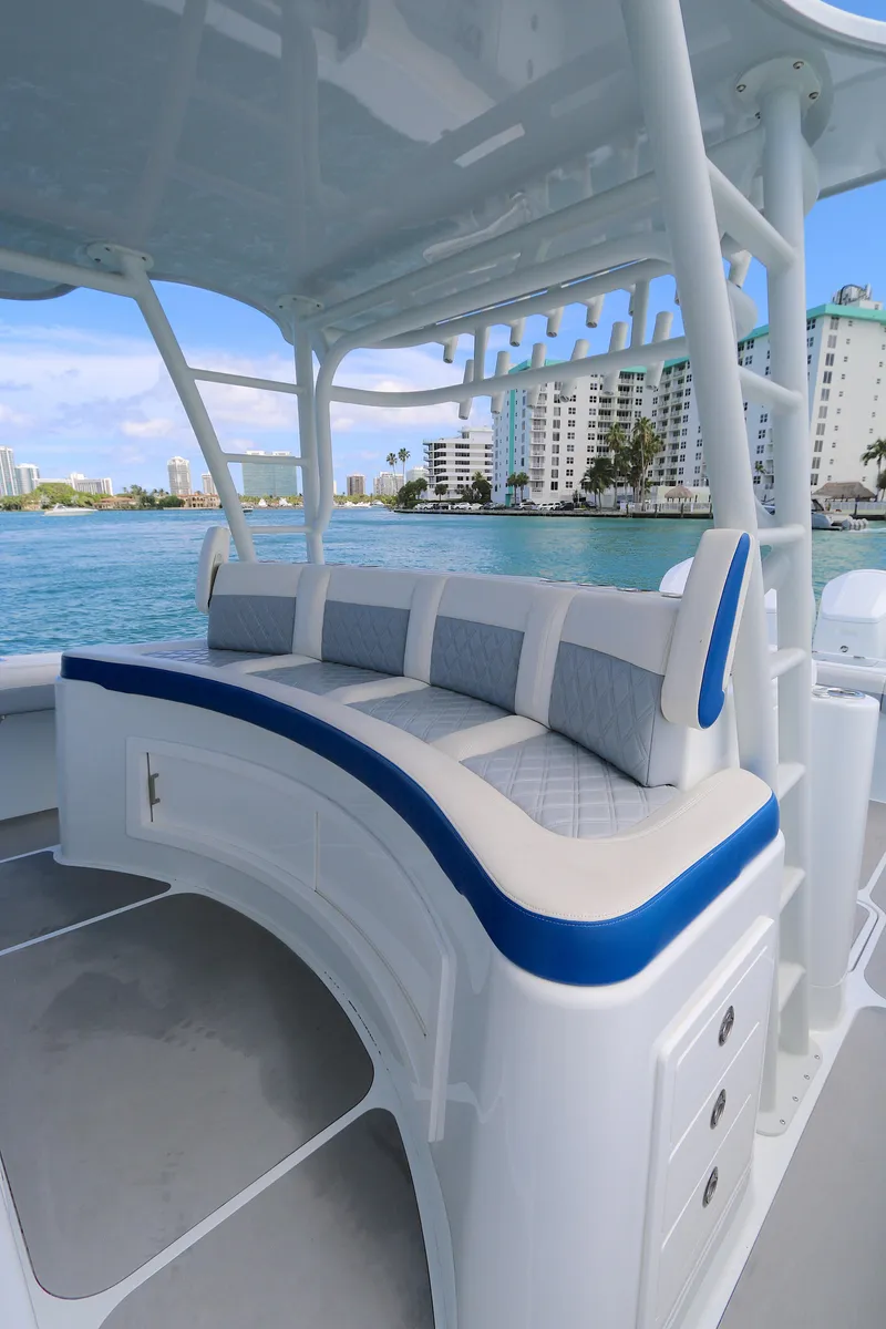 Slide: The Image of 2021 Yellowfin 54 Offshore boat with cushioned seating, docked near waterfront buildings. - 7