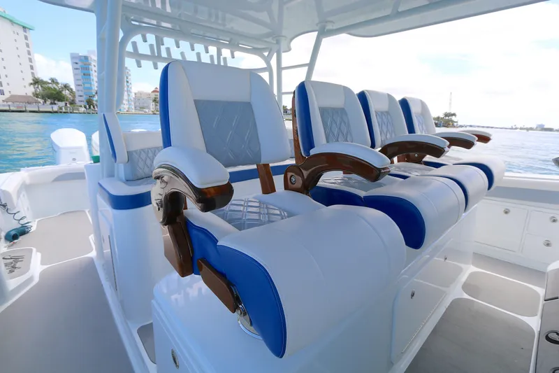 Slide: The Image of Luxurious seating on 2021 Yellowfin 54 Offshore boat, featuring blue and white cushioned chairs. - 8