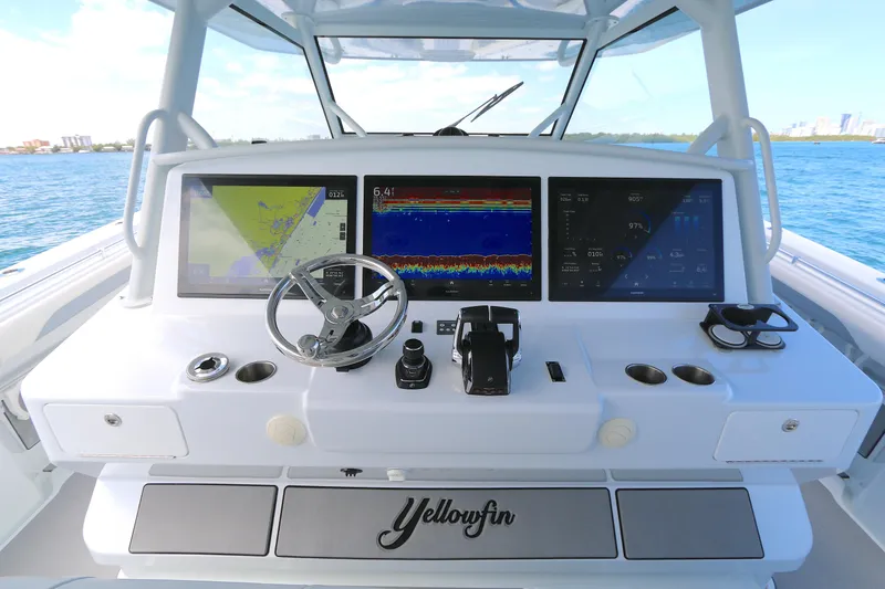 Slide: The Image of 2021 Yellowfin 54 Offshore boat dashboard with navigation screens and steering wheel. - 9