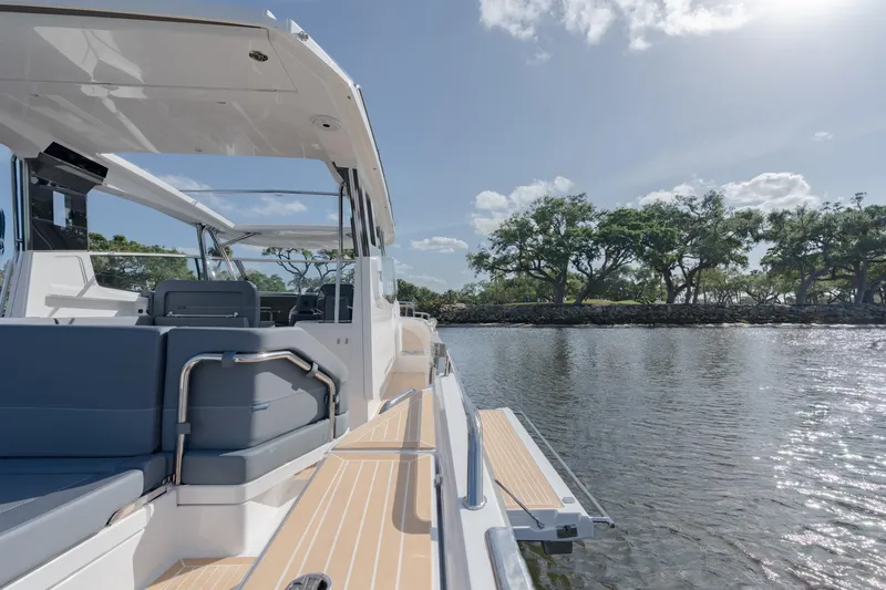 Slide: The Image of 2024 Nimbus Weekender 11 #20 boat on calm water with scenic background. - 13