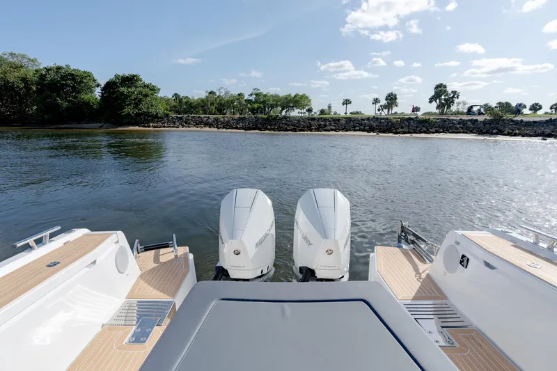 Slide: The Image of 2024 Nimbus Weekender 11 #20 boat with twin outboard engines on calm water. - 17