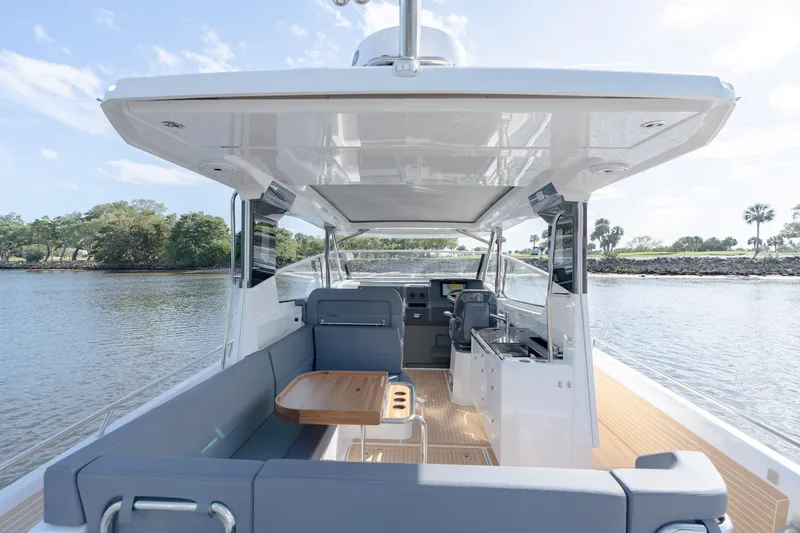 Slide: The Image of 2024 Nimbus Weekender 11 #20 boat interior with seating and table on a sunny day. - 6
