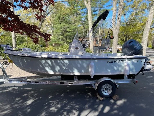Slide: The Image of 2023 Key West 1720 Center Console boat on a trailer in a wooded area. - 7