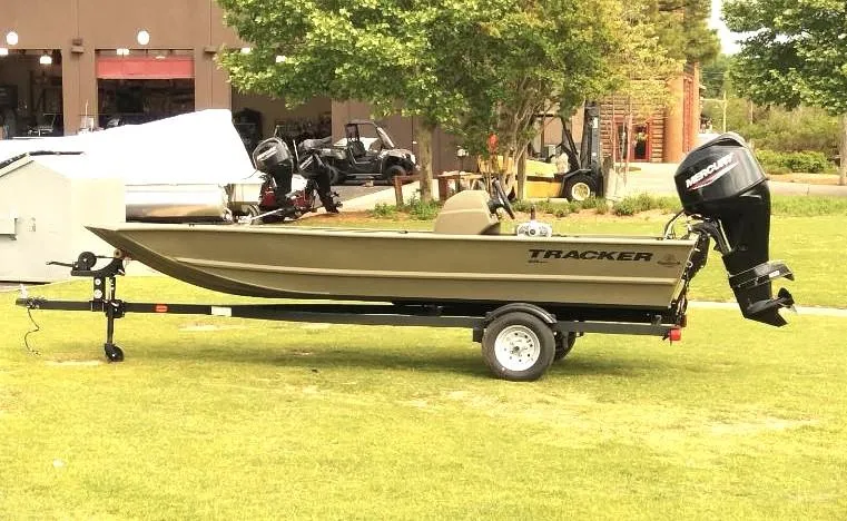 Slide: The Image of 2024 Tracker Grizzly 1648 SC boat on trailer, parked on grass. - 4