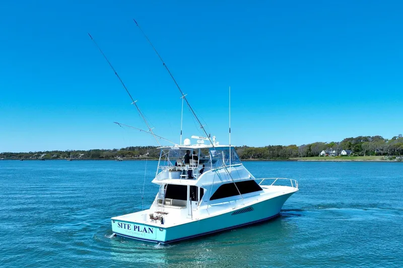 Slide: The Image of Viking 55 Convertible yacht from 2000 on calm blue waters, clear sky background. - 11