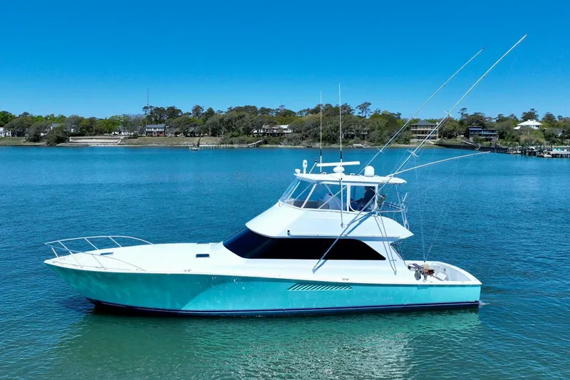 Slide: The Image of 2000 Viking 55 Convertible yacht on calm blue water under clear sky. - 13