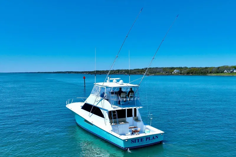 Slide: The Image of 2000 Viking 55 Convertible yacht on calm blue water under clear sky. - 23
