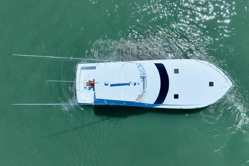 Slide: The Image of Aerial view of 2000 Viking 55 Convertible yacht cruising in clear green water. - 24