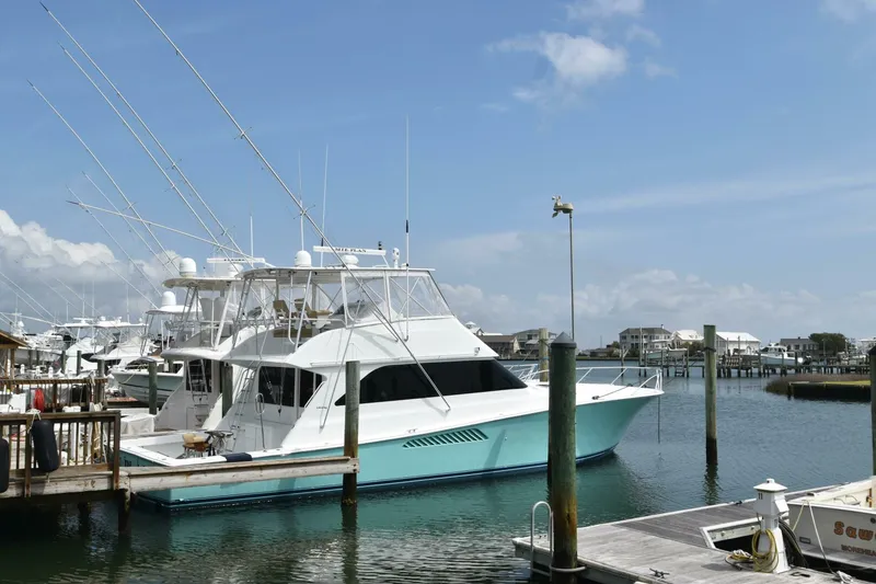 Slide: The Image of 2000 Viking 55 Convertible yacht docked at marina under clear blue sky. - 26