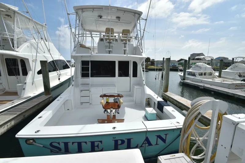 Slide: The Image of 2000 Viking 55 Convertible yacht docked at marina under blue sky. - 30