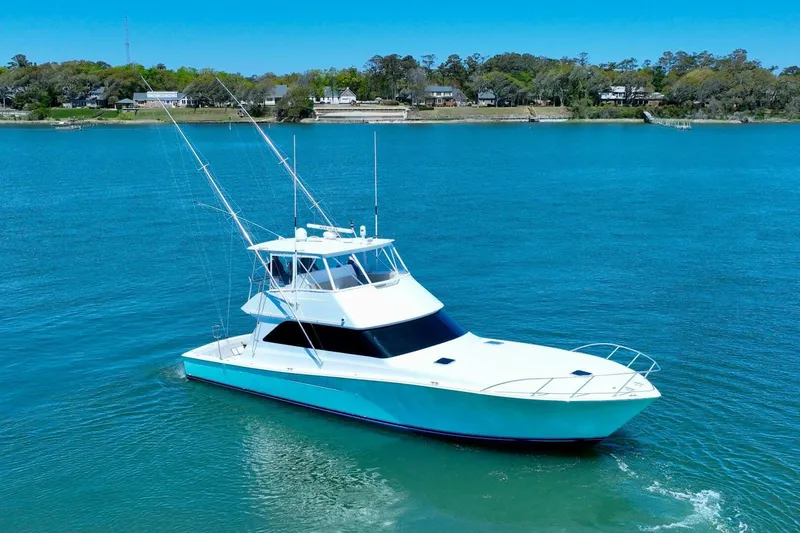 Slide: The Image of 2000 Viking 55 Convertible yacht cruising on a serene blue lake. - 9