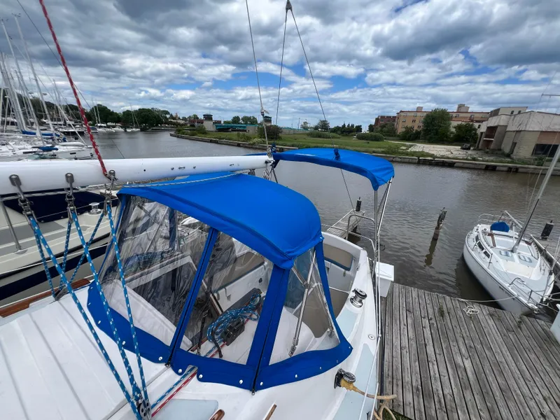 Slide: The Image of 1983 Hunter 27 sailboat docked with blue canvas covers. - 11